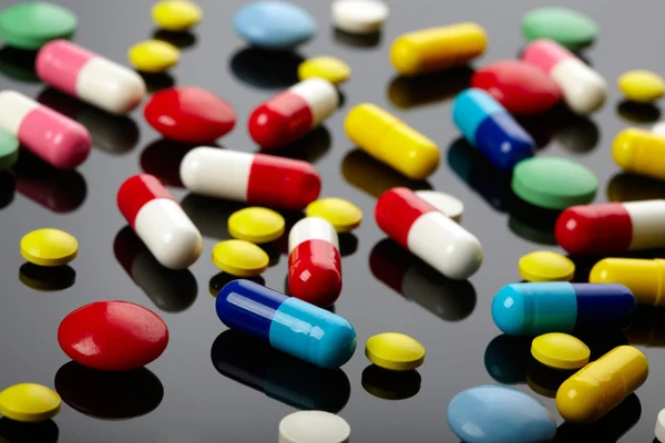 stock image Colorful pills over dark background