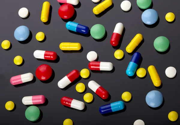 Coloridas píldoras sobre fondo oscuro — Foto de Stock