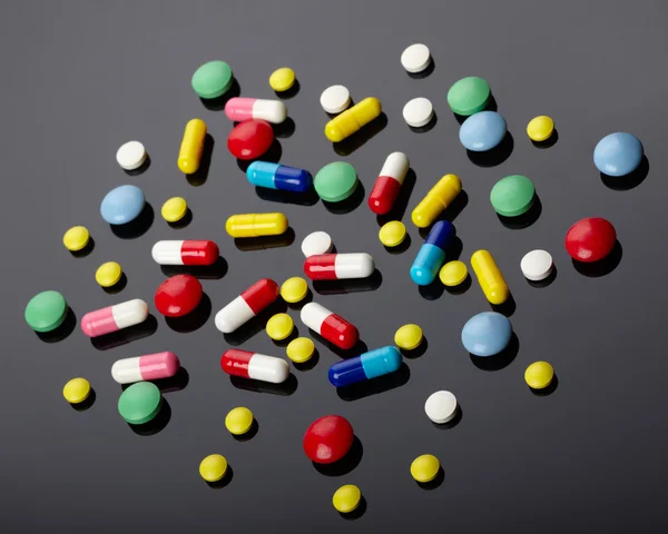 Colorful pills over dark background — Stock Photo, Image
