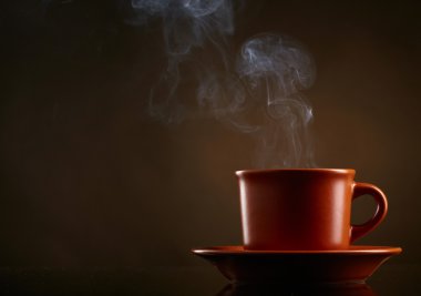 Cup of coffee over dark background clipart