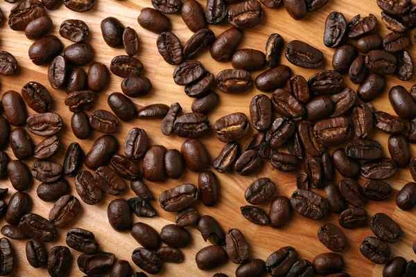 Кофейные зерна на деревянном фоне — стоковое фото