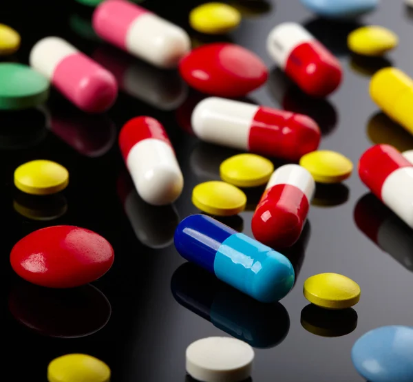 Stock image Colorful pills over dark background