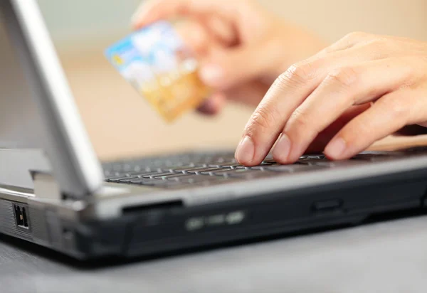 Hands holding credit card and laptop. Shallow DOF — Stock Photo, Image