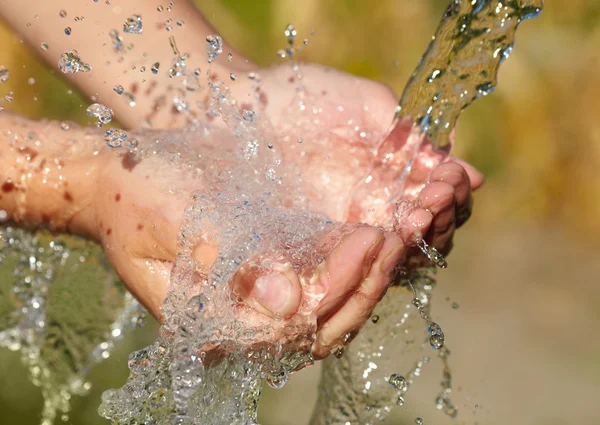 Ženské ruce s stříkající vodě — Stock fotografie