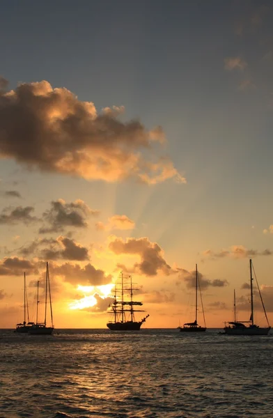 Atardecer caribeño y silueta del barco y veleros —  Fotos de Stock
