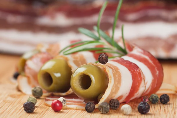 Smoked bacon with olives and rosemary — Stock Photo, Image