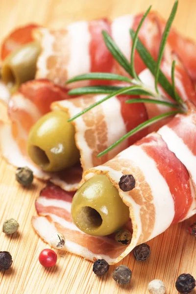 Раскатанный бекон с оливками и перцем — стоковое фото