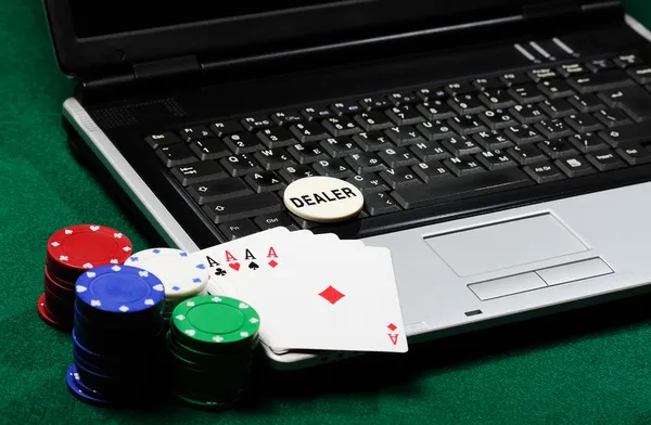 Fichas de jogo e cartões de poker em um laptop — Fotografia de Stock