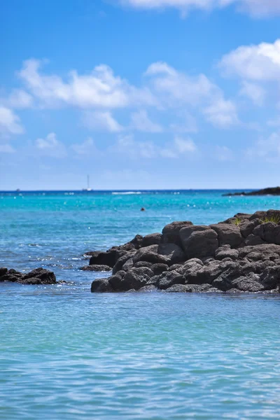 Zwarte stenen in de zee. Mauritius — Stockfoto