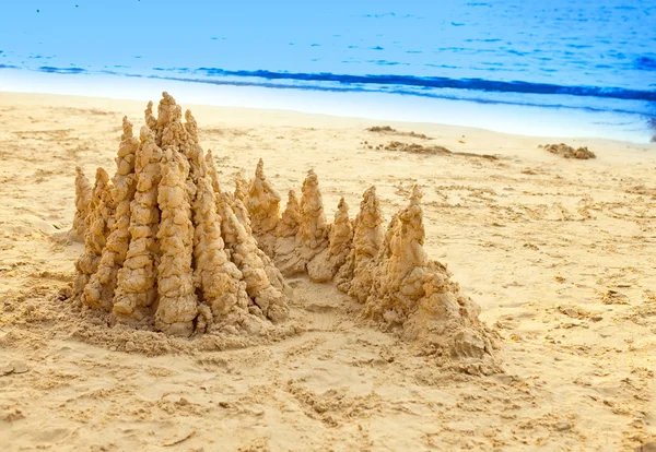 Sandy castle at the sea edge — Stock Photo, Image