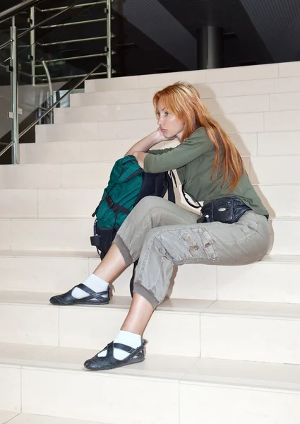 A menina com uma mochila de estrada em uma sala de espera da estação — Fotografia de Stock