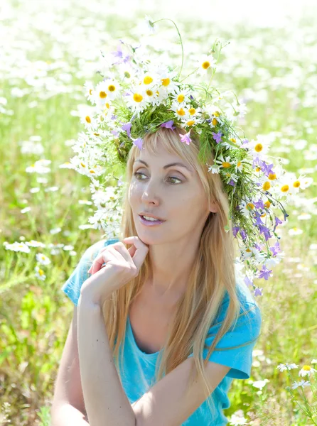 मैदान में जंगली फूलों से एक मुकुट में खुश युवा महिला — स्टॉक फ़ोटो, इमेज
