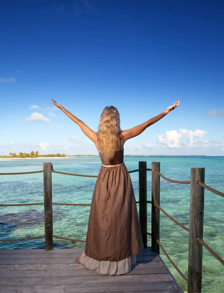The young beautiful woman on a wooden platform over the sea — Stock Photo, Image