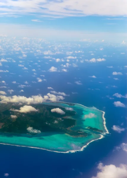 Полинезия. Кольцо атолла в океане видно сквозь облака. Вид с воздуха . — стоковое фото