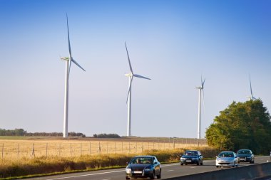 Wind-powered generators along highway clipart