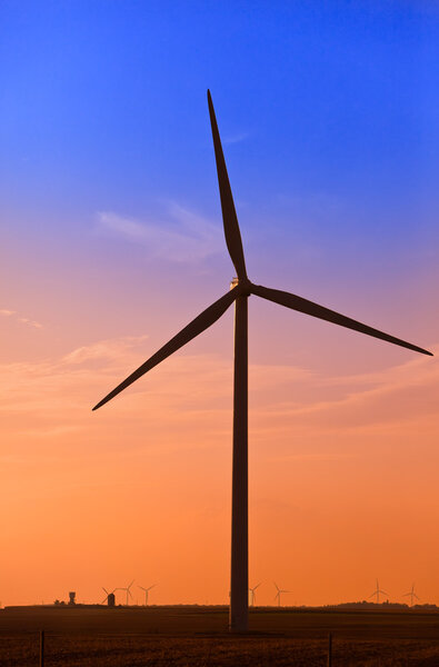 Silhouette of wind turbines against the sunset sky