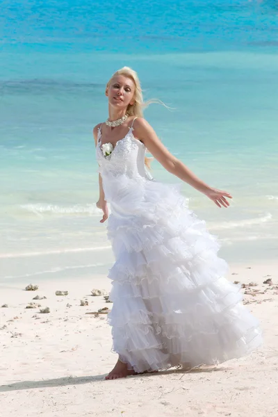 Die junge schöne Frau im Kleid der Braut, die am Rande des Meeres steht — Stockfoto