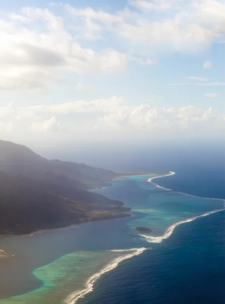 Polinésia. O anel do atol no oceano é visível através das nuvens. Vista aérea . — Fotografia de Stock