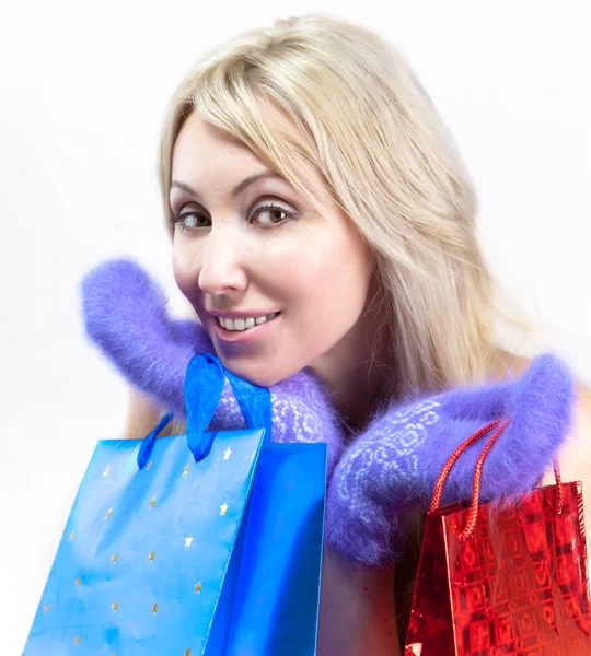 Den unga kvinnan i ljusa vantar med eleganta paket jublar till vintern — Stockfoto