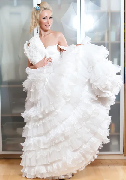 Молодая женщина с свадебным платьем в руках мечтает о свадьбе — стоковое фото