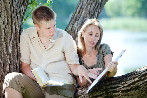 Νεαρός άντρας και το κορίτσι προετοιμασία για τα μαθήματα, εξέταση στο πάρκο άνοιξη — Φωτογραφία Αρχείου