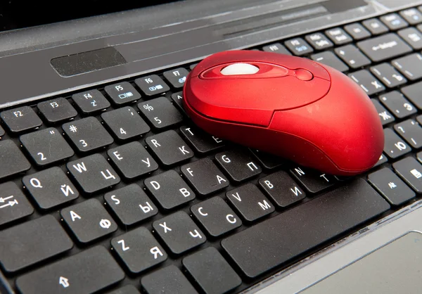 stock image The red computer mouse on the black keyboard