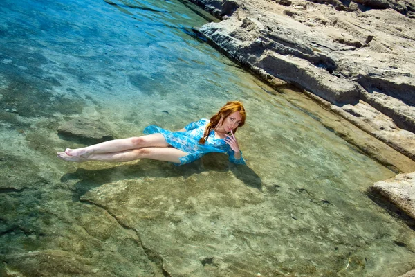 Den unga vackra kvinnan i en naturlig havet simning badar bland stenar. — Stockfoto