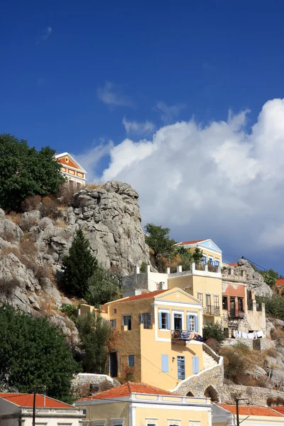 Yunanistan. Dodecanesse. Symi (simi) Adası. kayaların üzerinde renkli evleri. — Stok fotoğraf