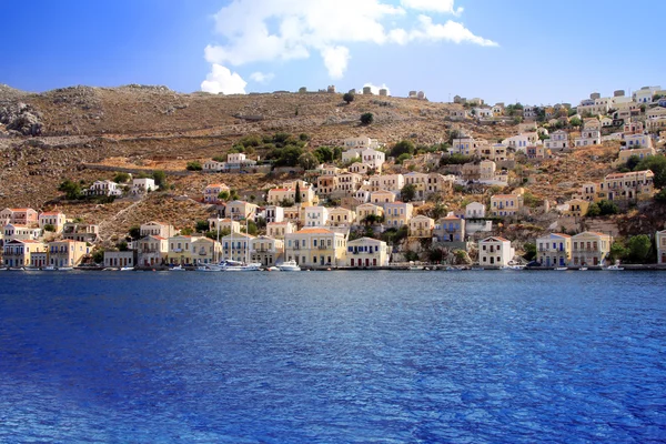 Grecja. dodecanesse. Wyspa symi (simi). kolorowe domy na skałach. — Zdjęcie stockowe