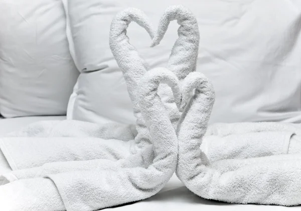 Swans twisted from towel - greeting in hotel — Stock Photo, Image