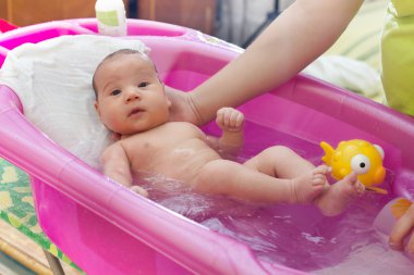 Adorable baby having bath clipart