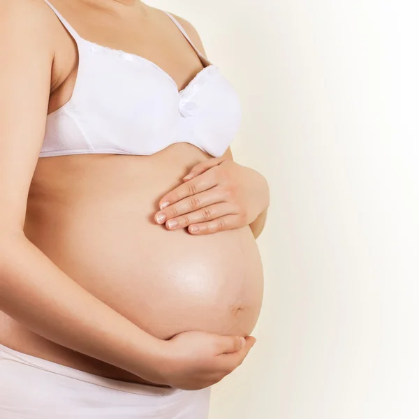 Donna incinta prendersi cura del suo ventre — Foto Stock