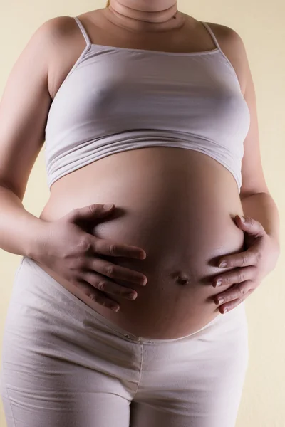 怀孕的女人照顾她的肚子里 — 图库照片