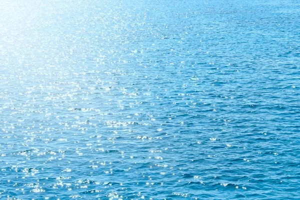 Reflejo de la luz solar sobre la superficie azul del mar — Foto de Stock