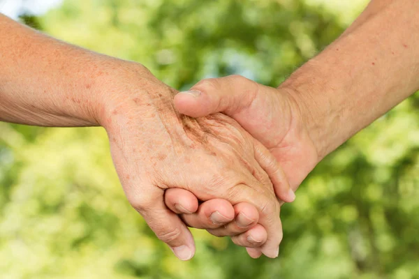 Closeup of old hands holding together — Stockfoto