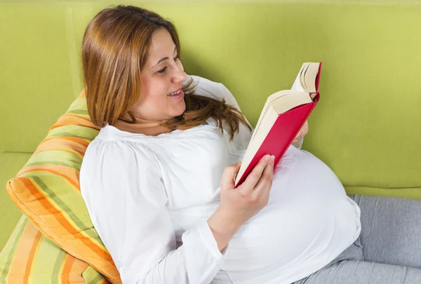 Mulher grávida feliz lendo um livro — Fotografia de Stock