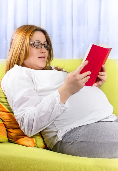 Щаслива вагітна жінка читає книгу — стокове фото