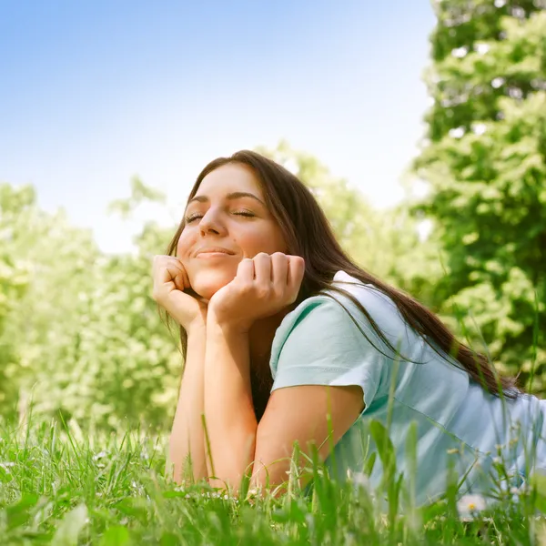 Bella giovane donna che si rilassa nel parco nella soleggiata giornata primaverile — Foto Stock