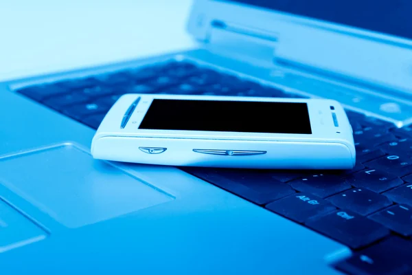 Сотовый телефон на ноутбуке как бизнес-концепция — стоковое фото