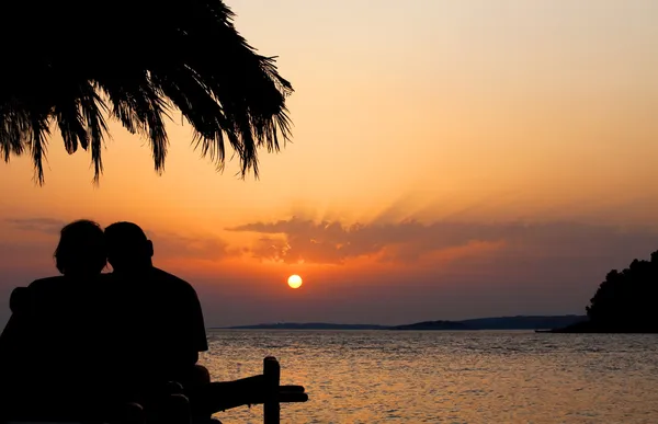 คู่รักที่ชายหาดตอนพระอาทิตย์ตก — ภาพถ่ายสต็อก
