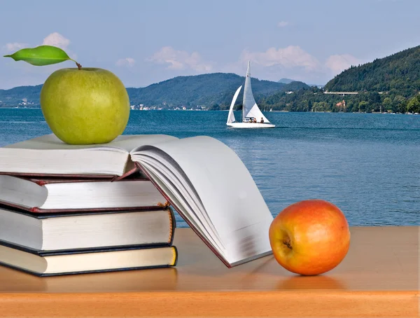 Bücher und Äpfel auf dem Schreibtisch — Stockfoto