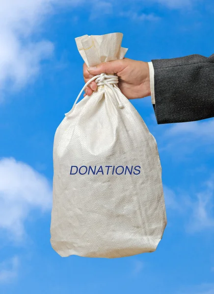 Hand med väska av donationer — Stockfoto