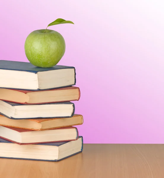 Πράσινο μήλο στα βιβλία στο γραφείο — Φωτογραφία Αρχείου