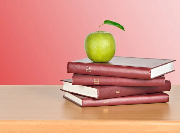 Groene appel op boeken — Stockfoto