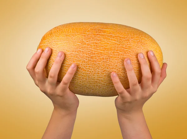 Meloun v rukou izolovaných na žlutém podkladu — Stock fotografie