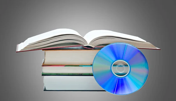Pile of books, open book, and DVD disk as symbols of old and ne — Stock Photo, Image