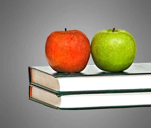 Červená a zelená jablka na knihy na stole — Stock fotografie
