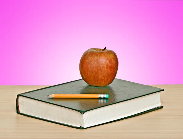 Κόκκινο μήλο και μολύβι πάνω από το βιβλίο — Φωτογραφία Αρχείου