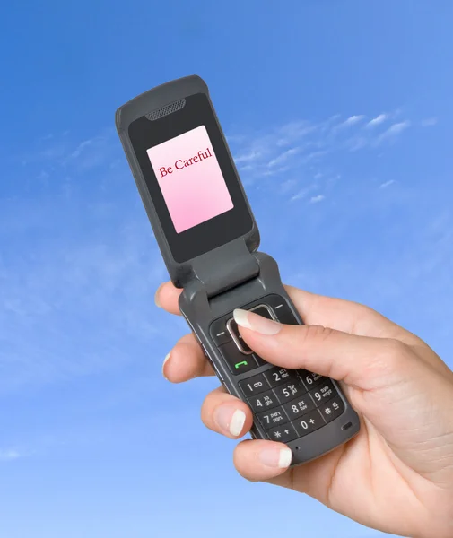 Мобильный телефон с этикеткой "Будь осторожен" на экране — стоковое фото