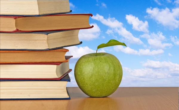 Zelené jablko a knihy — Stock fotografie